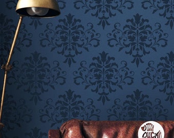 May include: A dark blue wall with a damask pattern stencil. The stencil is repeated throughout the wall. A gold lamp and a brown leather couch are in the foreground.