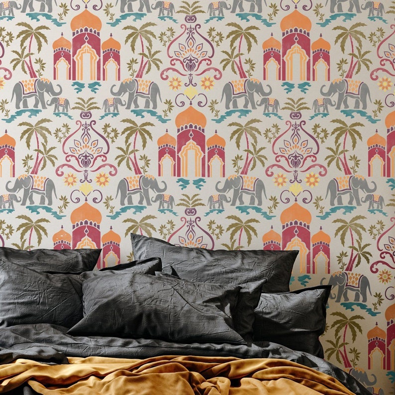May include: A bed with a grey headboard and a gold throw blanket. The headboard features a patterned wallpaper with elephants, arches, and palm trees in shades of orange, red, yellow, and blue.