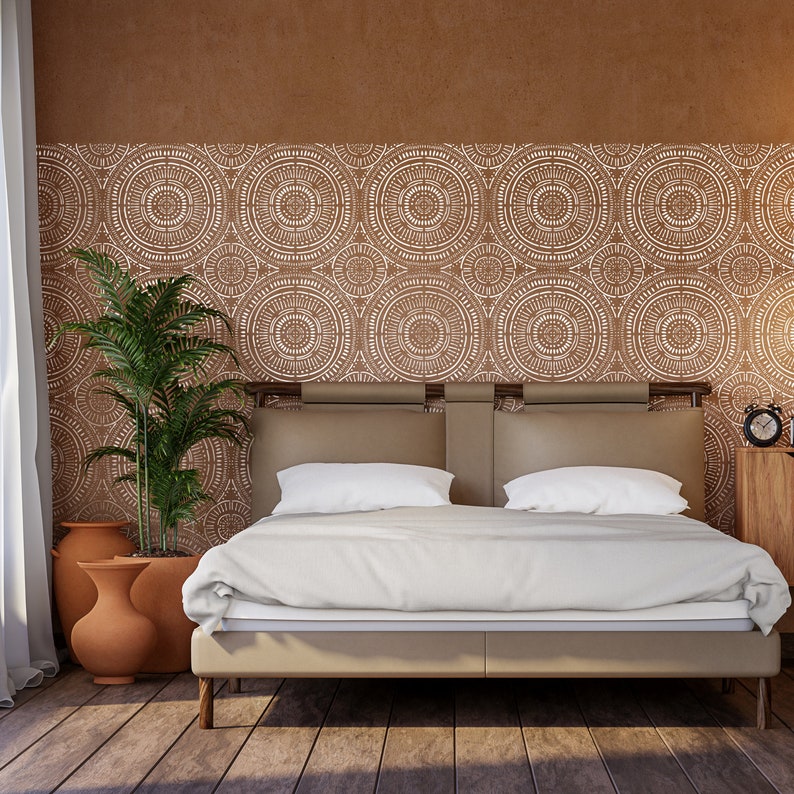 May include: A white bed with a brown headboard and a white bedspread. The headboard features a geometric pattern of circles. There are two potted plants in the room.