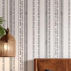 May include: White wall with black vertical stripe pattern. The design includes lines of triangles and diagonal lines. A brown woven pendant light hangs from the ceiling. A brown leather headboard is visible.