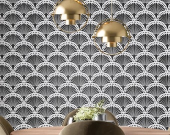 May include: A dining room with a black and white geometric patterned wallpaper. Three gold pendant lights hang over a wooden table with two chairs.