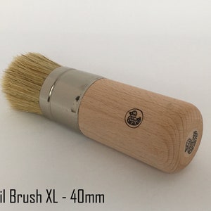 Könnte beinhalten: Ein Stencilpinsel mit Holzgriff und einem 40 mm breiten, naturhaarigen Bürstenkopf. Der Pinsel hat eine silberne Metallzwinge und einen Holzgriff mit einem kleinen Entenlogo.