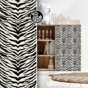May include: Black and white zebra print wallpaper with a wood grain texture. The wallpaper is applied to a wooden cabinet with shelves. The cabinet is decorated with a white stuffed animal, wooden toys, and books.