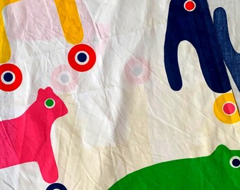 Può includere: Tessuto bianco con un motivo ripetuto di forme di animali colorate e stilizzate. Gli animali sono gialli, rosa, verdi e blu, ciascuno con ruote. Le ruote sono rosse con centri blu e gialli. Il design è giocoso e stravagante.