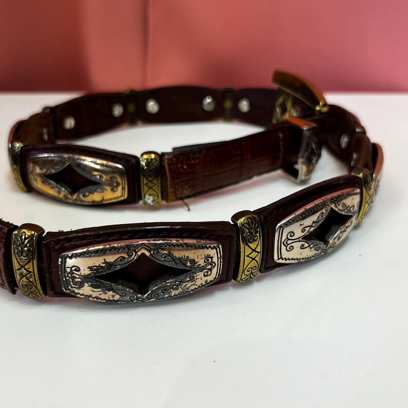 May include: A white ceramic mug with a black handle and the text "But First, Coffee" in a handwritten style. The mug is on a white surface. The mug is 4 inches tall.