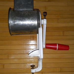 Molinillo de frutos secos alemán vintage con pomo rojo esmaltado en blanco.