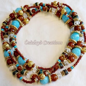 May include: A multi-strand beaded necklace featuring turquoise, brown, gold, and clear beads. The necklace has a mix of bead sizes and textures, with a dark red string. The text "Òsàdayò Creations" is visible.