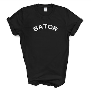 May include: Black t-shirt with white text that reads "BATOR" in a curved font.