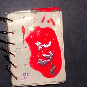 A7 Notizbuch mit rotem Splatter und Blattgold. Leuchtet im Dunkeln.