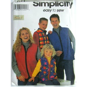 May include: A Simplicity easy to sew pattern envelope featuring four individuals wearing fleece vests. The vests are shown in solid red, a multi-coloured plaid, a solid blue, and a blue fabric with a colourful star pattern. The text reads Simplicity.
