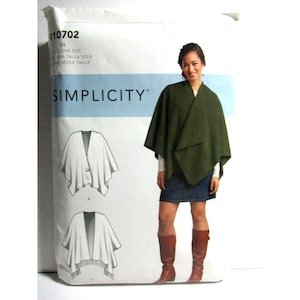 Op de afbeelding: Een Simplicity naaipatroon envelop R10702 voor een poncho in één maat. De verpakking toont een foto van een persoon die een donker olijfgroene poncho draagt over een blauwe spijkerrok en bruine laarzen, naast twee lijntekeningen van het kledingstuk.