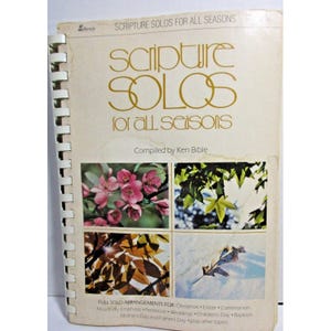 May include: A book titled "Scripture Solos for All Seasons" compiled by Ken Bible. The cover features four images of trees and flowers representing the four seasons.