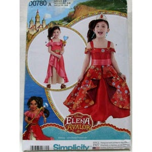 Puede incluir: Patrón de costura Simplicity para un disfraz infantil de Elena de Avalor. El patrón incluye un vestido rojo con detalles florales, un cinturón y una corona. Tallas 3-8.
