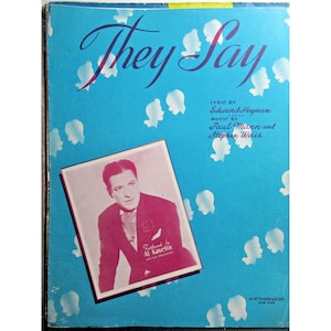Puede incluir: Una portada de partitura vintage para la canción "They Say" con una foto en blanco y negro de Al Kavelin y su orquesta. La portada es azul con flores estilizadas blancas y el texto "They Say" en una fuente grande y cursiva.