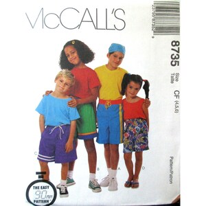 Può includere: Modello McCall's 8735 per abbigliamento per bambini. L'immagine mostra un gruppo di bambini che indossano i vestiti che possono essere realizzati con il modello. Il modello include pantaloncini e top. Il testo sul modello recita "The Easy 90 Pattern".