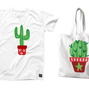 May include: Two white tote bags with a green cactus design. One bag is a t-shirt and the other is a tote bag. Both bags feature a red pot with white snowflakes and a red pot with white stripes and a star.