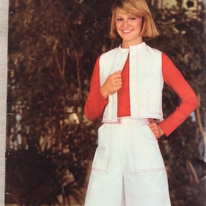 May include: Vintage sewing pattern titled "See & Sew PATTERNS" featuring a woman wearing a white vest and culottes with red stitching over a red long-sleeve shirt. The pattern is size 14.