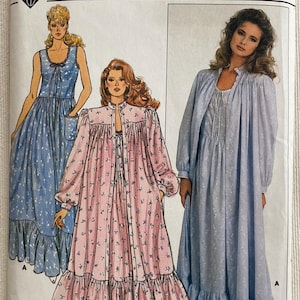 May include: A white ceramic mug with a black handle and the text "But First, Coffee" in a black, handwritten-style font. The mug is on a white surface.