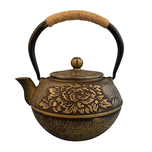May include: A black cast iron teapot with a gold floral design and a rope handle. The teapot has a round body and a lid with a knob.