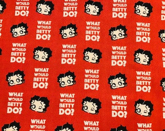 Op de afbeelding: Rode stof met een herhalend patroon van een cartoonfiguur met de tekst "What would Betty do?"