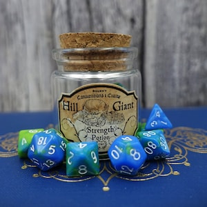 May include: A glass jar with a cork lid and a label that reads "Hill Giant" and "Strength Potion". The jar is surrounded by blue and green dice with white numbers.