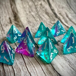 K&ouml;nnte beinhalten: Ein Satz von acht schillernden blauen und violetten W&uuml;rfeln mit wei&szlig;en Zahlen. Die W&uuml;rfel sind in Form von vierseitigen Pyramiden.