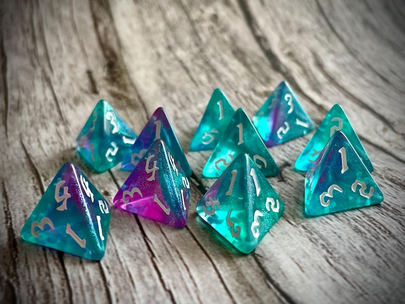 K&ouml;nnte beinhalten: Ein Satz von acht schillernden blauen und violetten W&uuml;rfeln mit wei&szlig;en Zahlen. Die W&uuml;rfel sind in Form von vierseitigen Pyramiden.