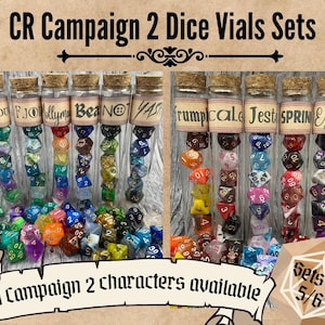 May include: A set of 10 glass vials filled with colourful dice. The vials are labelled with names such as "Cadu", "FJO", "Holly", "Bea", "NO", "YAS", "Trumpicale", "Jest", "SPRIN", and "Essel". The vials are arranged in two rows of five. The text "All Campaign 2 characters available" is at the bottom of the image. The text "Sets of 5/6" is in the lower right corner of the image.