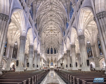 May include: A view of the interior of a large cathedral with high vaulted ceilings and stained glass windows. The pews are empty and the floor is tiled.