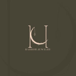 Harbor Jewelry custom logo design — elegant serif monogram HJ with crescent moon and hanging diamond pendant. Luxury jewellery brand identity by 90Designs.