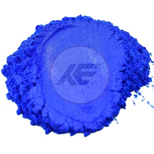 May include: A vibrant pile of bright blue powder, possibly pigment or dye, against a white background. The powder has a fine texture and is slightly textured. A watermark with the letters "KE" is visible in the center.
