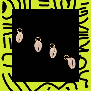 May include: Four gold shell charms with a white shell design. The charms are on a black background.