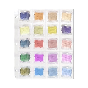 May include: A clear plastic storage sheet with 20 slots for holding spools of thread. Each slot has a small label with a number on it. The thread spools are in various colors, including blue, yellow, pink, green, and purple.