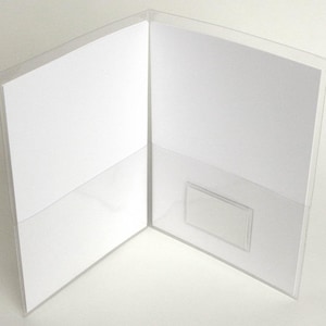 May include: A clear plastic folder with a pocket on the left side and a smaller pocket on the right side. The folder is open and the pockets are empty.