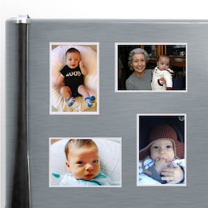 May include: A collage of four photos on a silver background. The photos feature babies and a grandmother holding a baby. One photo shows a baby wearing a black onesie with the word "HOORAY" printed on it. Another photo shows a baby wearing a brown knitted hat. The remaining two photos show babies wearing blue clothing.