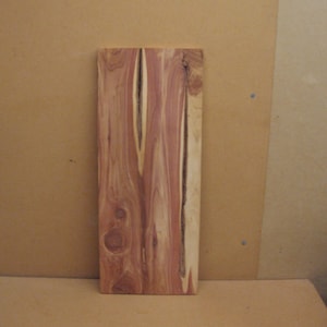 Longer red cedar board with two long streaks of bark inside, good color
