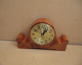 Cypress  mantle clock with brass face, and an interesting shape.