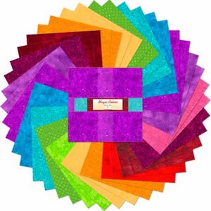May include: A collection of colorful fabric squares arranged in a circular pattern. The squares display a variety of hues, including pink, purple, blue, green, orange, and red. A central bundle of purple fabric is wrapped with a label that reads "Magic Colors".