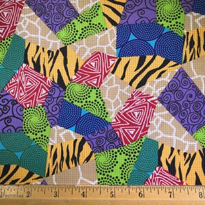 May include: Colorful fabric with a patchwork design featuring geometric shapes, animal prints, and swirls. The fabric is beige with a white grid pattern.