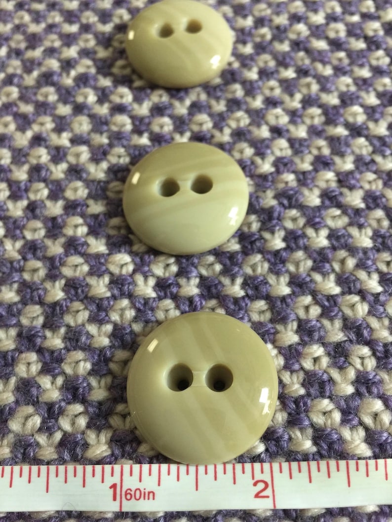 May include: Three beige buttons with two holes each. The buttons are approximately 1 inch in diameter and have a striped pattern.