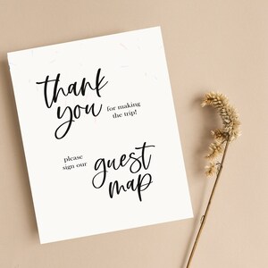 May include: White card with black calligraphy that reads "Thank you for making the trip!" and "Please sign our guest map".