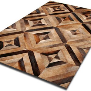 May include: A geometric patterned rug made from brown and tan leather hides. The rug has a diamond pattern with stripes.