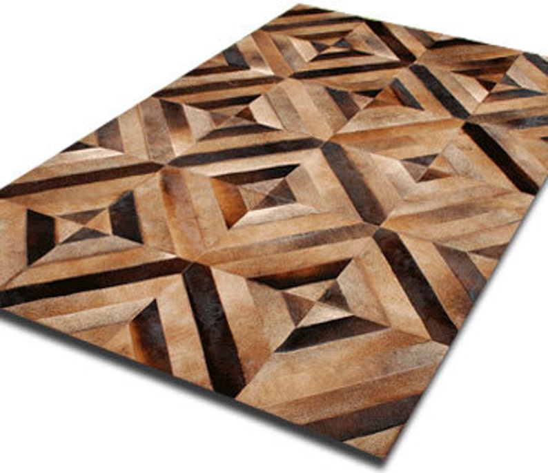 May include: A geometric patterned rug made from brown and tan leather hides. The rug has a diamond pattern with stripes.