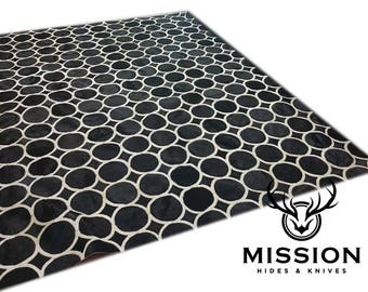 Può includere: Tappeto in pelle di mucca nero e bianco con un motivo geometrico di cerchi. Il tappeto è realizzato in vera pelle e ha una sensazione morbida e lussuosa.