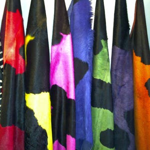 May include: A collection of colorful fabric swatches, including black and white zebra print, red and white, yellow and black, pink and black, blue and black, green and black, orange and black, and a solid black swatch.