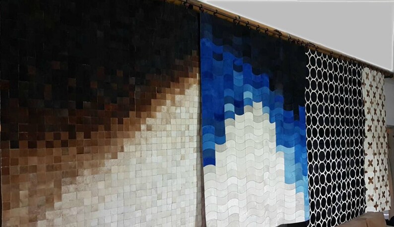 May include: Three different cowhide rugs with geometric patterns. The first rug is a gradient of brown to white, the second rug is a gradient of blue to white, and the third rug is a black and white pattern of circles.