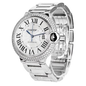 Puede incluir: Un reloj Cartier Ballon Bleu de Cartier plateado con un bisel engastado con diamantes y una esfera blanca. El reloj presenta marcadores de hora en n&uacute;meros romanos, una aguja de acero azul y una ventana de fecha a las 3 en punto. El reloj es autom&aacute;tico y tiene un cristal de zafiro.