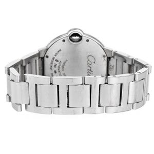 Puede incluir: Un reloj Cartier plateado con una esfera redonda y una correa de acero inoxidable. La esfera del reloj tiene las palabras "Cartier" y "Automatic" impresas. El reloj es resistente al agua hasta 30 metros.