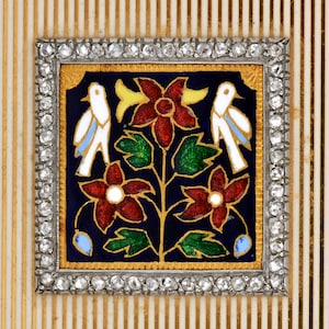 May include: A gold and silver frame with a blue background and a floral design. The design features two white birds, red flowers, and green leaves. The frame is decorated with diamonds.