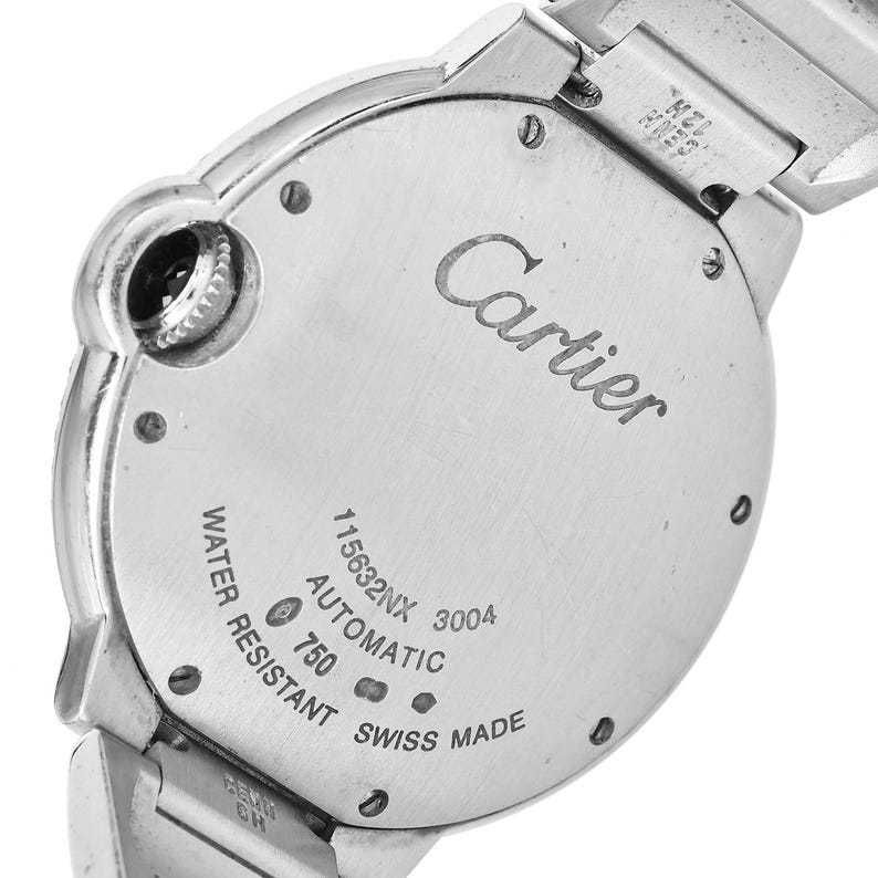 Puede incluir: Un reloj de pulsera Cartier plateado con una esfera redonda y una correa plateada. La esfera del reloj tiene las palabras "Cartier", "Automatic", "Swiss Made", "Water Resistant" y "115632NX 3004" impresas en ella.